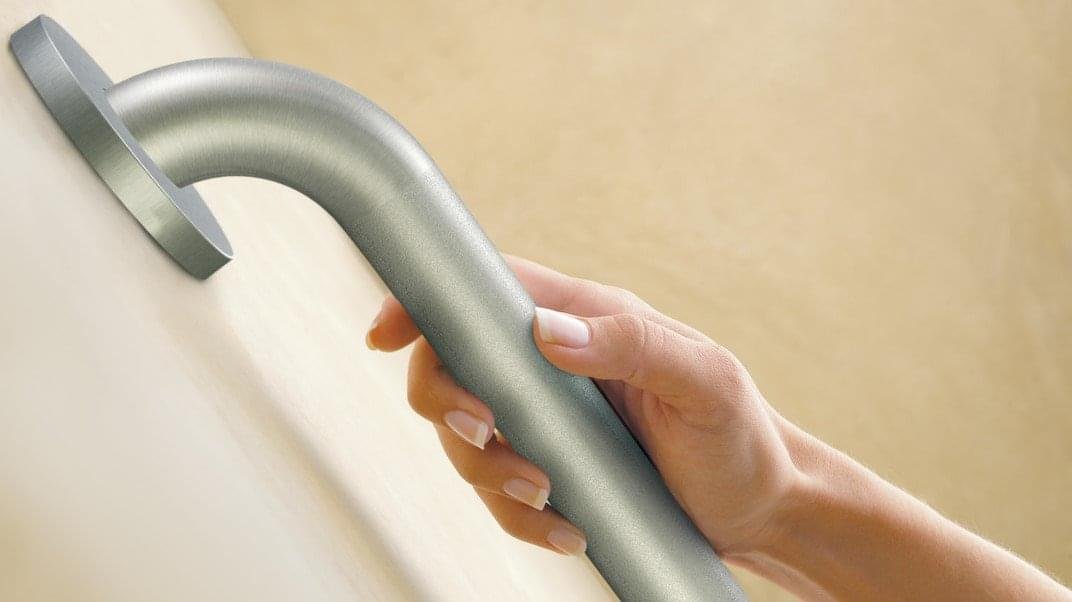 a stainless steel grab bar in a bathroom